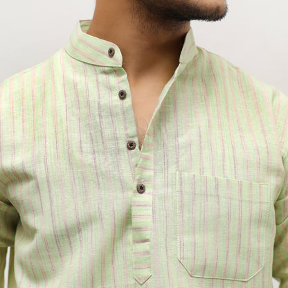 Light green shirt with pink stripes worn by a person on a plain background