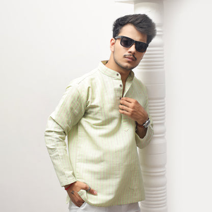 Man wearing a light-colored traditional outfit with sunglasses against a white background