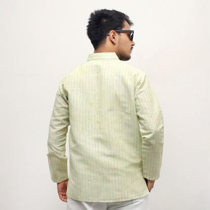 Man wearing a light green traditional jacket on a white background